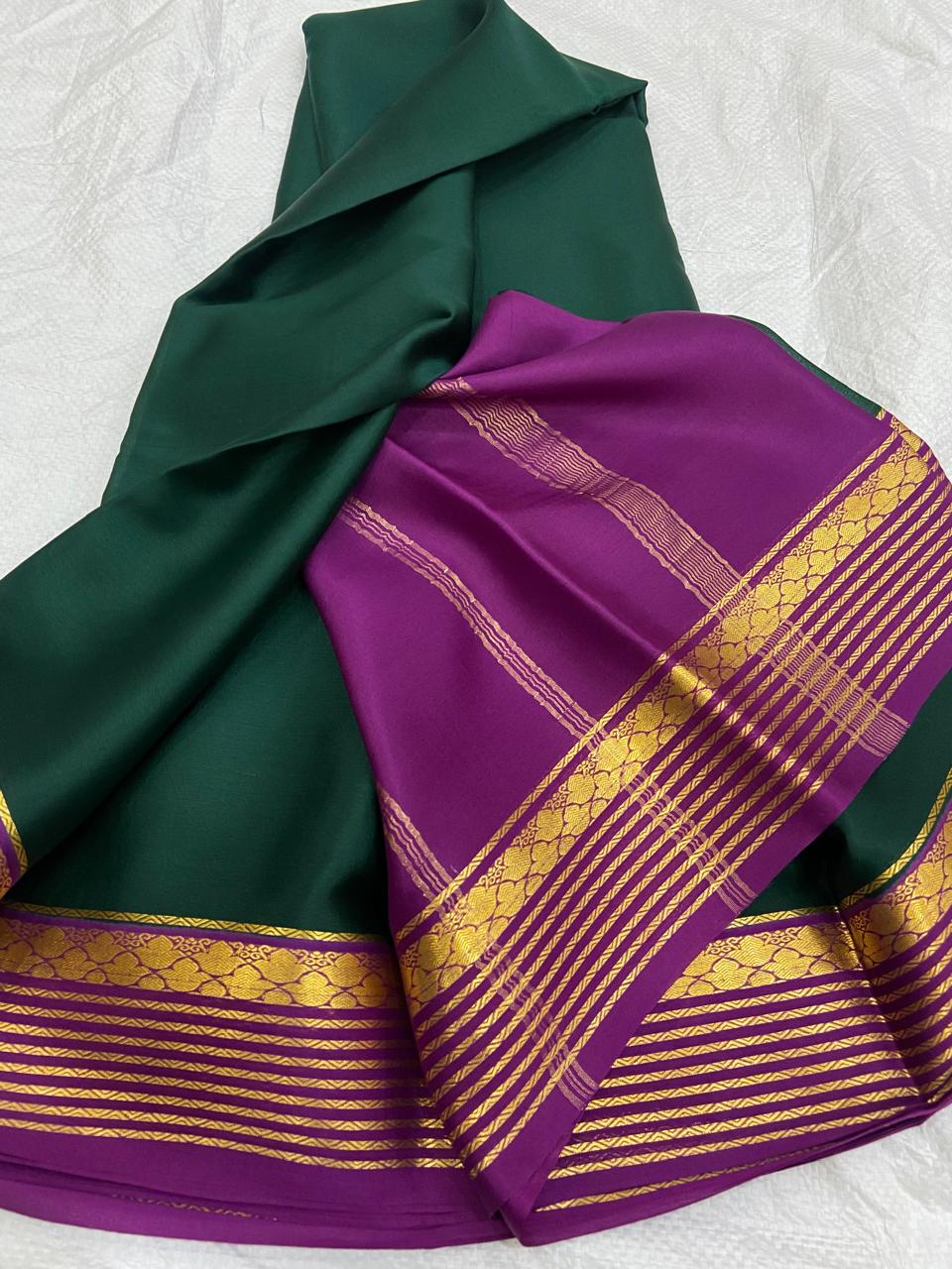 The Modern Classic: Dark Green and purple pure Mysore Crepe Silk saree with gold border on a white background