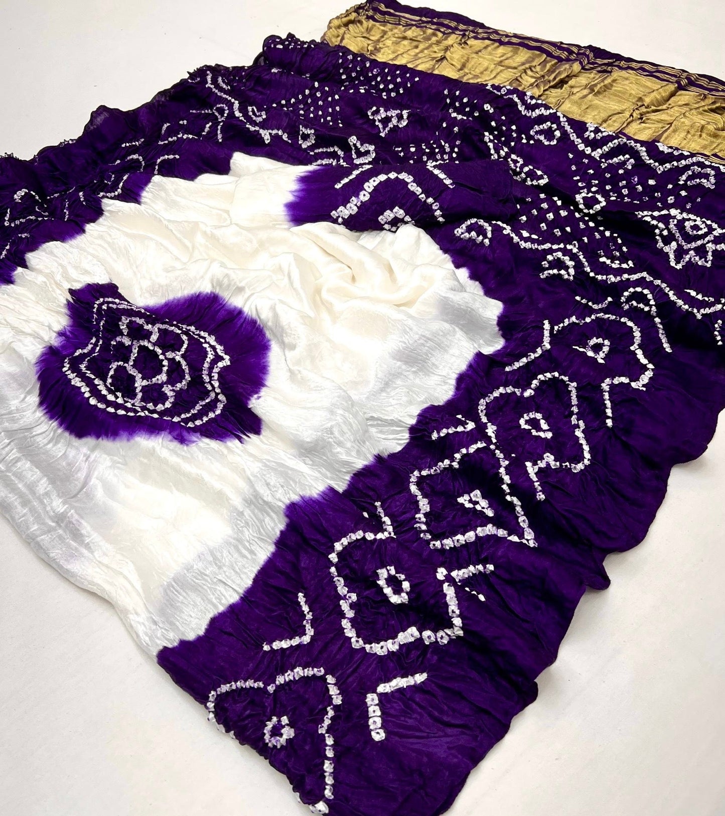 Luxurious Gajji silk saree adorned with vibrant contrast Bandhani patterns, ideal for festive and special occasions.