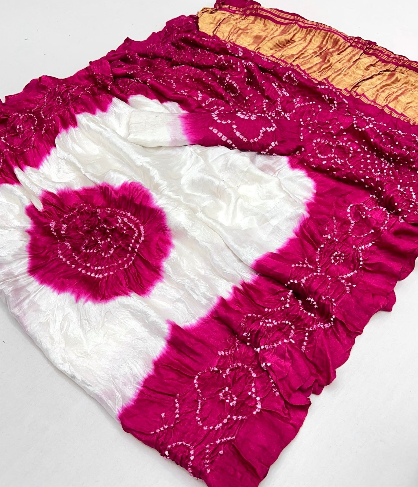 Luxurious Gajji silk saree adorned with vibrant contrast Bandhani patterns, ideal for festive and special occasions.